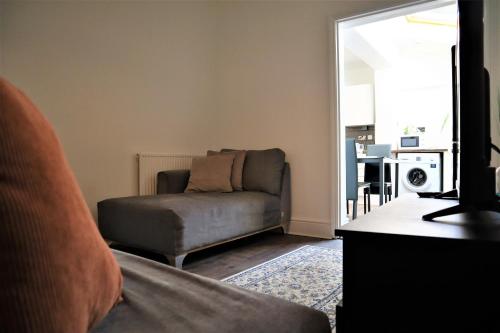 a living room with a couch and a television at Victoria 4 bedroom Serviced House Short Lets - Near Northampton Gen Hosp & Town Centre in Northampton