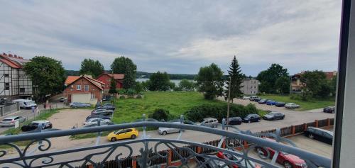 a balcony with a view of a parking lot with cars at Apartament Z widokiem na Czos Mrągowo in Mrągowo