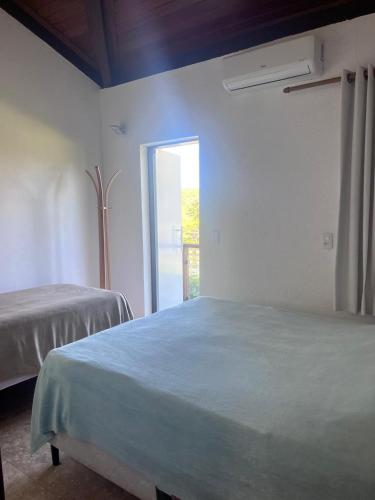 a bedroom with a large bed with a window at Casa do Deck Inesquecível - Escarpas do Lago in Capitólio