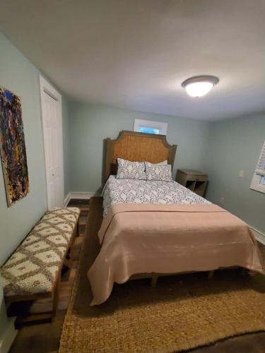 a bedroom with a bed and a bench in it at Pet friendly minutes to beach in Marlyn Manor