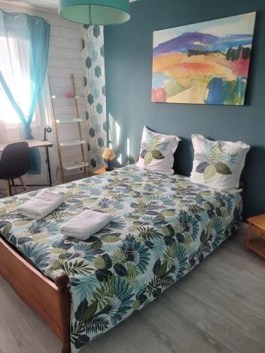 une chambre avec un grand lit avec un mur bleu dans l'établissement Appartement proche Espace Anjou, à Angers