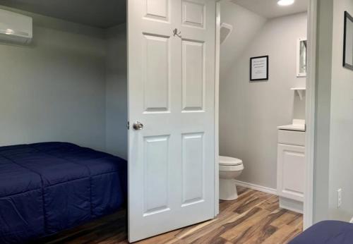 bagno con letto e porta bianca di Black House Mountain ATV Campground a Jamestown