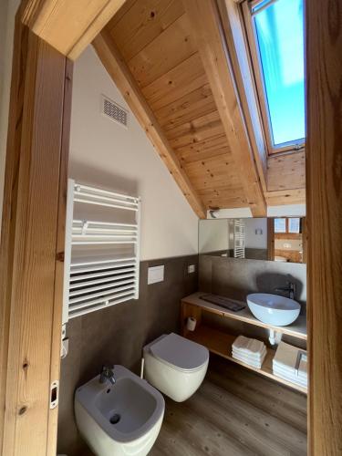 een badkamer met een wastafel en een toilet en een raam bij Chalet Shany in Livigno