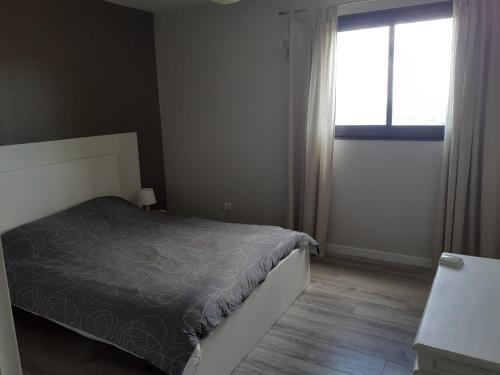 a bedroom with a bed and a window at La hautcsur la colline in Yzeron