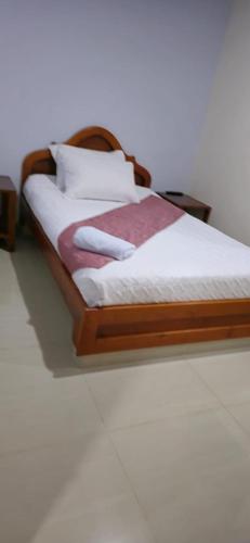 a bed with a wooden frame and white sheets and pillows at Hotel kristal campestre in San Francisco