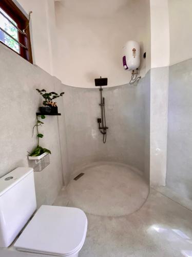 a white bathroom with a toilet and a sink at The Palm Private Cottages Midigama in Midigama