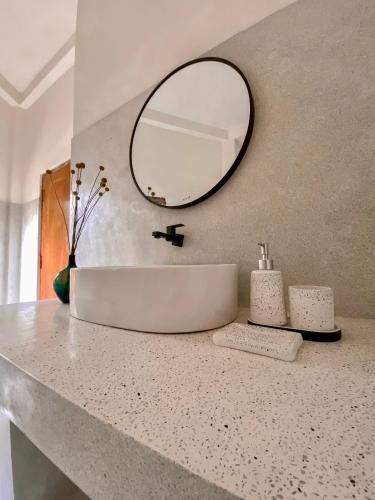 a bathroom with a sink and a mirror on a counter at The Palm Private Cottages Midigama in Midigama