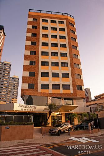 a large building with a car parked in front of it at Maredomus Hotel in Fortaleza