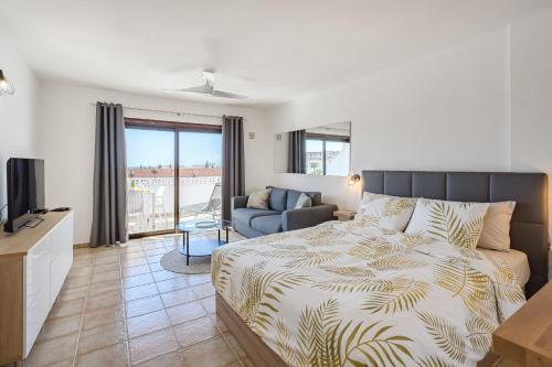 a bedroom with a bed and a living room at Costa Adeje Heated Pool Marina Primavera in Adeje
