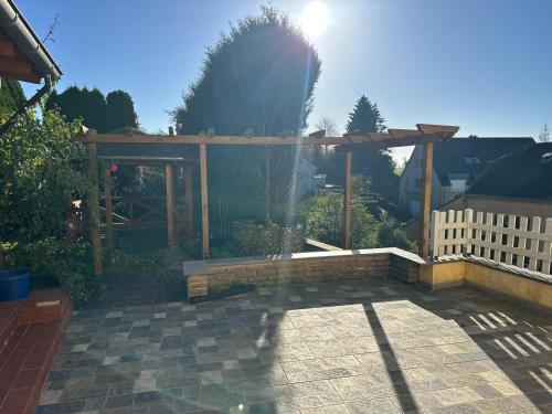 a wooden pergola in a yard with a brick patio at Cosy House in Dippach