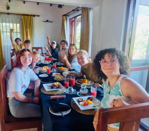 Un grupo de personas sentadas en una mesa comiendo comida en Grand Kandy Villa, en Kandy