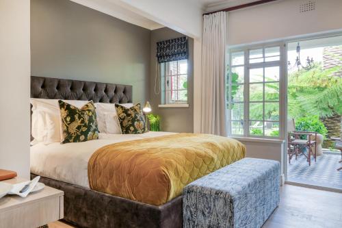 a bedroom with a large bed with a large window at Villa Coloniale Schumacher Luxury Retreat, Adults Only in Cape Town