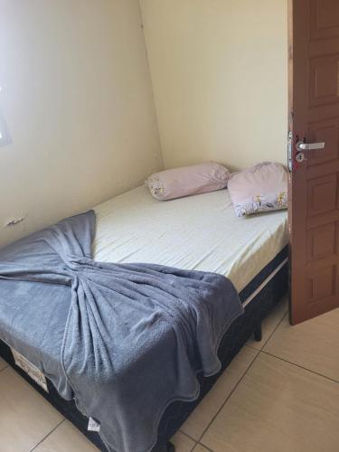a small bed with two pillows on it in a room at Pousada Por Do Sol 2 andar in Palhoça
