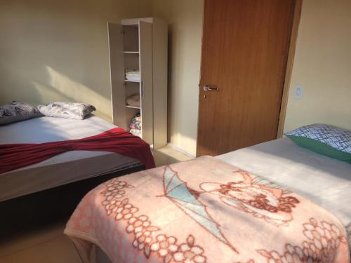 a bedroom with two beds with a blanket on it at Pousada Por Do Sol 2 andar in Palhoça