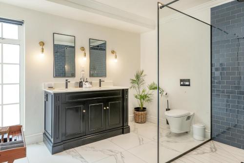 a bathroom with a black vanity and a toilet at Villa Coloniale Schumacher Luxury Retreat, Adults Only in Cape Town
