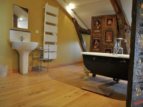 un bagno con vasca e lavandino di Gite Nogaro a Perchède