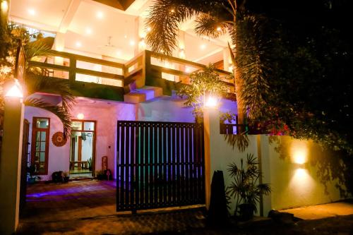 a house with a gate at night with lights at Costels Mirissa in Mirissa