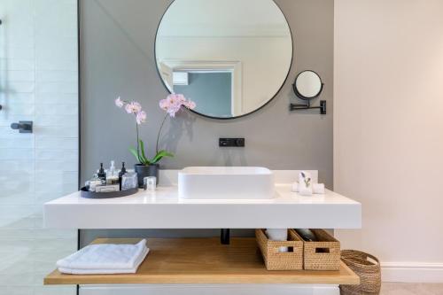 a bathroom with a sink and a mirror at Villa Coloniale Schumacher Luxury Retreat, Adults Only in Cape Town