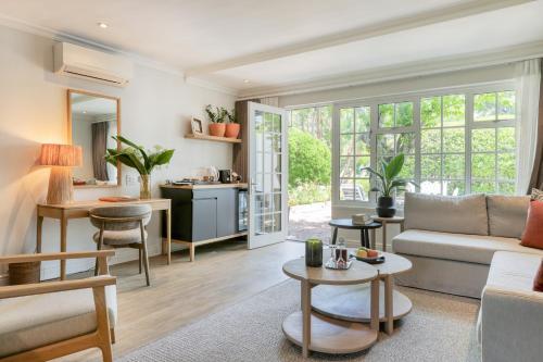 a living room with a couch and a table at Villa Coloniale Schumacher Luxury Retreat, Adults Only in Cape Town