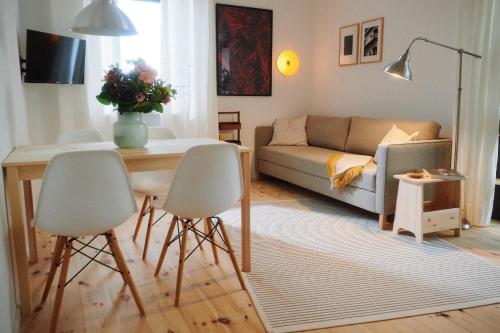 ein Wohnzimmer mit einer Couch und einem Tisch und Stühlen in der Unterkunft Chiemsee Cottage in Prien am Chiemsee