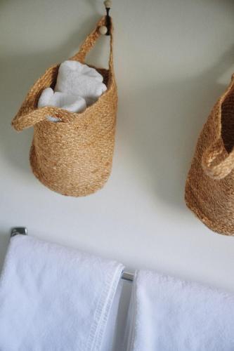 a basket of towels is hanging on a wall at Chiemsee Cottage in Prien am Chiemsee