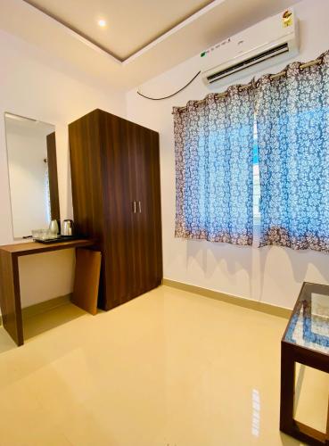 a room with a cabinet and a window at Tulips Inn Mysuru in Mysore