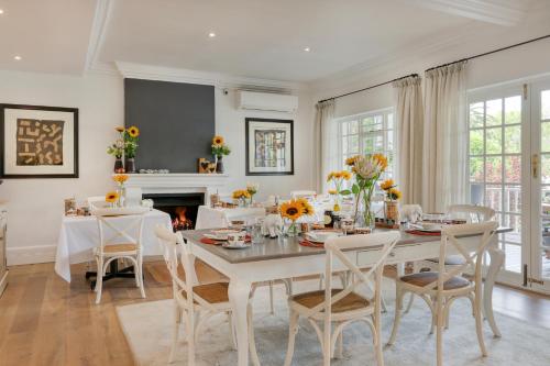 a dining room with a table and chairs and a fireplace at Villa Coloniale Schumacher Luxury Retreat, Adults Only in Cape Town