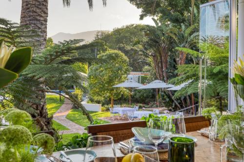 a dining room with a view of a garden at Villa Coloniale Schumacher Luxury Retreat, Adults Only in Cape Town