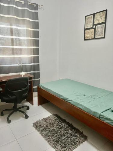 a bedroom with a bed and a desk and a chair at Spacious 3 bedroom in Swatar - Birkirkara in Birkirkara