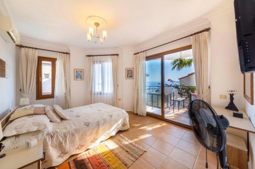 a bedroom with a bed and a balcony at Villa Miramar Kalkan in Kalkan