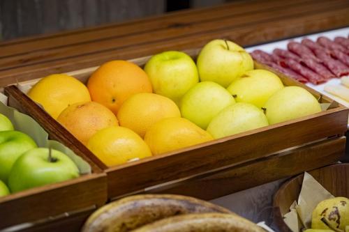 a bunch of apples and oranges in wooden boxes at Hotel President - Vintage Hotel in centro in Riccione