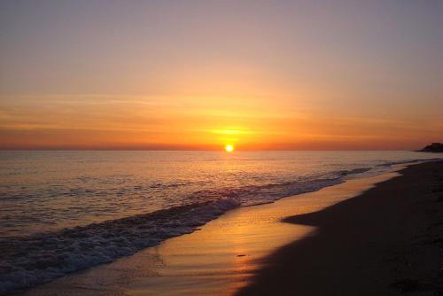 a sunset on a beach with the ocean at Golden Beach Sea View in Néa Meságkala