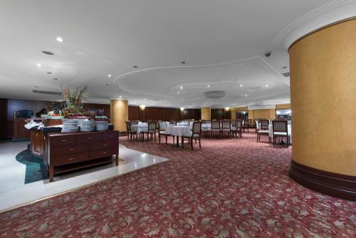 アンカラにあるAkar International Hotelのホテルのロビーには、テーブルと椅子付きのダイニングルームがあります。