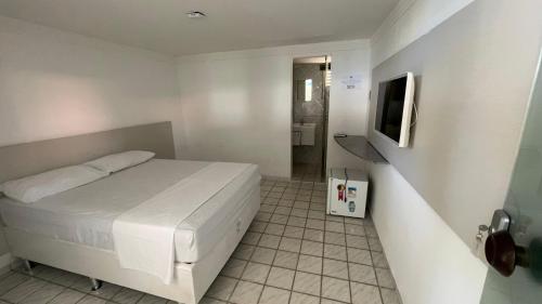 a small bedroom with a bed and a television at Pousada e Hostel Natal in Natal