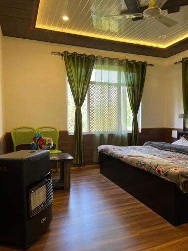 a bedroom with a bed and a tv and a table at Everest Guest House in Gulmarg