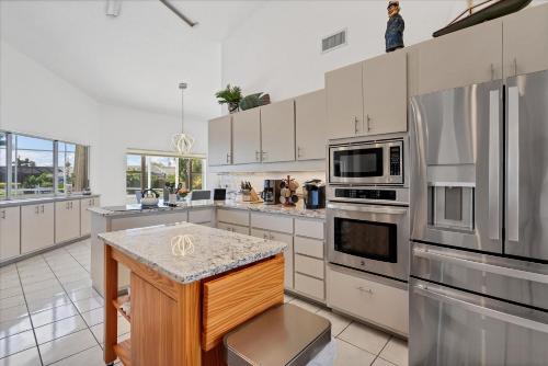 a kitchen with white cabinets and stainless steel appliances at 265 Belvedere in Punta Gorda