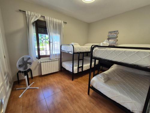 a room with three bunk beds and a window at El Jardín de los Niños 2 in El Viso de San Juan