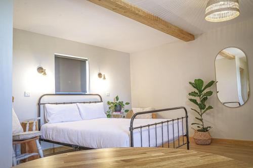 a bedroom with a bed and a table and a mirror at Bryngwyn Guest Suite in Camrose