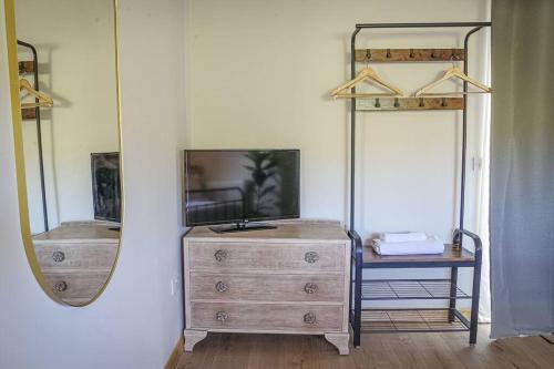 a room with a dresser and a mirror and a dresser with a dress at Bryngwyn Guest Suite in Camrose