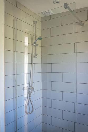 a shower in a bathroom with blue tiles at Bryngwyn Guest Suite in Camrose