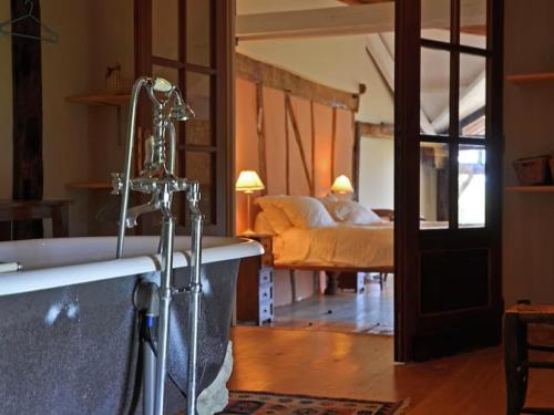 un bagno con vasca e un letto di Gite Nogaro a Perchède