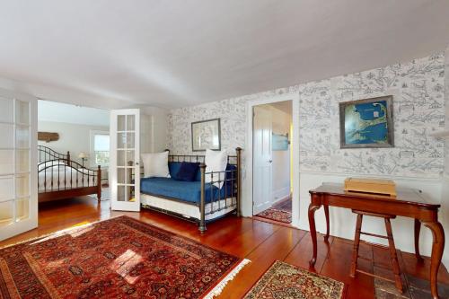 ein Wohnzimmer mit einem blauen Stuhl und einem Tisch in der Unterkunft Cape Landing Cottage in Brewster