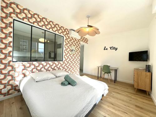 une chambre avec un grand lit et un mur qui dit ville dans l'établissement Le City, Centre-ville, Climatisation, Trams, à Grenoble