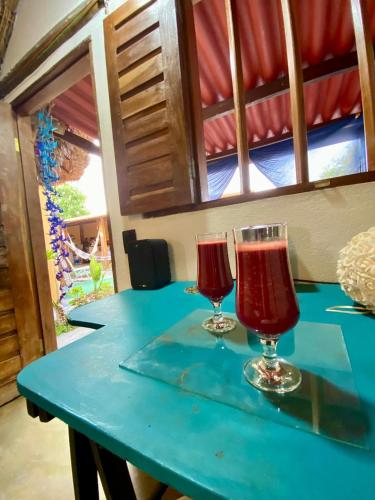 two wine glasses sitting on top of a blue table at Cabana Suíte da Casa Flor em Cavalcante in Cavalcante
