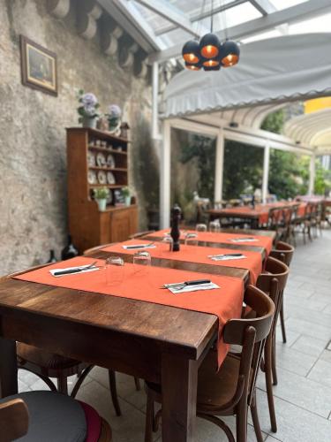 a dining room with tables and chairs with red table cloth at Hotel Croce Federale in Bellinzona
