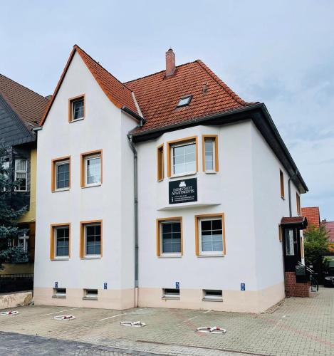 a white building with a sign on it at Domstadt Apartments in Merseburg