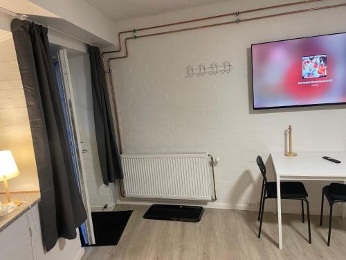 a room with a table and a tv on a wall at Apartment #1 with Wifi, close to city center, Beach and forrest in Aabenraa