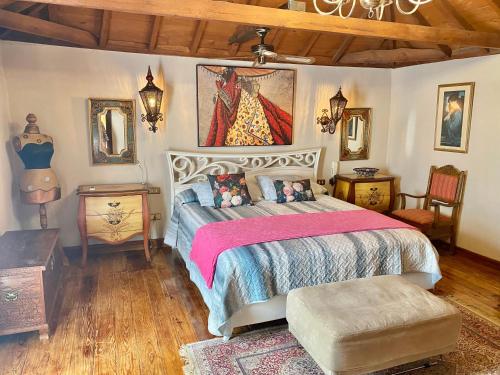 ein Schlafzimmer mit einem großen Bett mit einer rosa Decke in der Unterkunft Authentic Canary Style Villa with private pool and garden- Casa Juan Vera in Granadilla de Abona