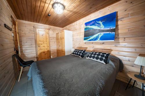a bedroom with a bed in a wooden cabin at Päärakka B Siivous lakanat ja pyyhkeet kuuluu in Levi