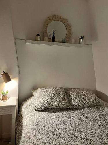 - une chambre avec un lit doté d'une tête de lit blanche et d'un miroir dans l'établissement Appartement T2 - Vue Tour Eiffel, à Paris